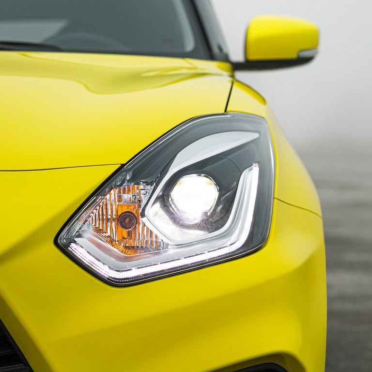 Detailaufnahme des linken Frontlichts eines Suzuki Swift Sport Hybrid in Champion Yellow