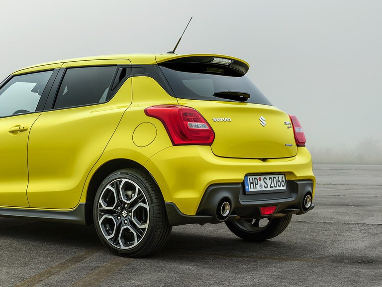 Aufnahme eines Suzuki Swift Sport Hybrid in Champion Yellow, schräg von hinten fotografiert