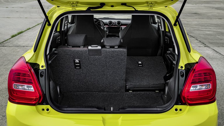 Suzuki Swift SportVon hinten fotografierter Suzuki Swift Sport Hybrid in Champion Yellow, Fokus auf dem offenen Gepäckraum. Gepäckraum