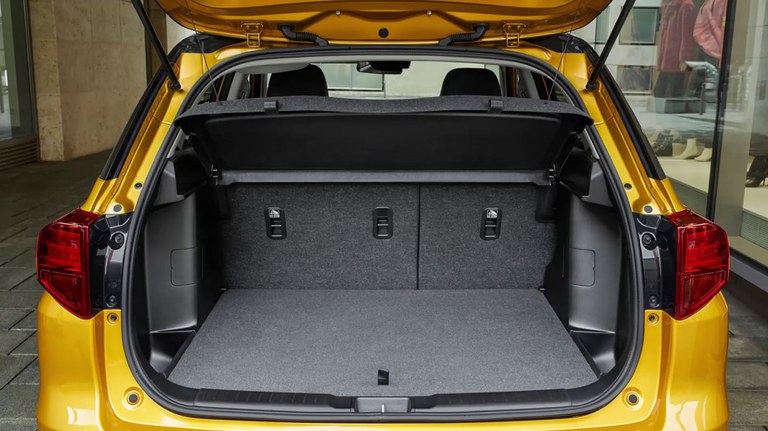 Schwarzer, geöffneter Gepäckraum eines Suzuki Vitara Hybrid in Solar Yellow Pearl Metallic